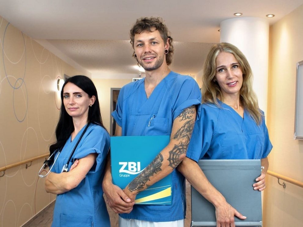 Stellenangebote in der außerklinischen Beatmung und Intensivpflege 3 Pflegefachkräfte des Zentrum für Beatmung und Intensivpflege (ZBI) in blauer Arbeitskleidung